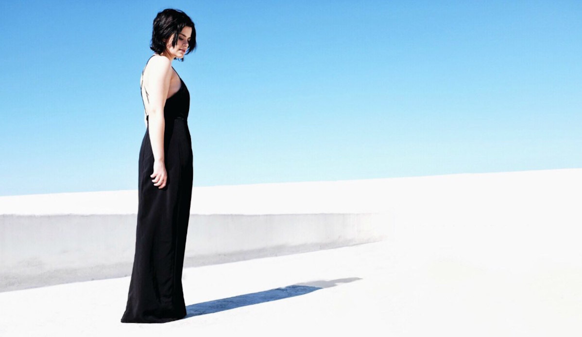 woman in black dress looking at white surface