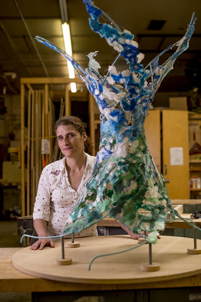 Dena Peake in her studio with a small scale model of “Current Collections.”