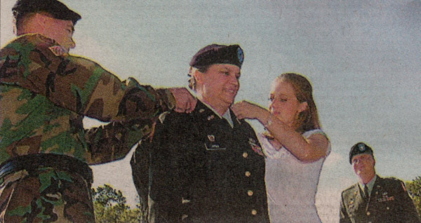 Maj. Gen. Hicks' 13-year-old daughter, Jennifer, and Gen. Byrnes pin the officer's shoulders with a second star, indicating her new rank as major general. Soldiers raised a two-star flag at the post. ANNETTE M. DROWLETTE/STAFF